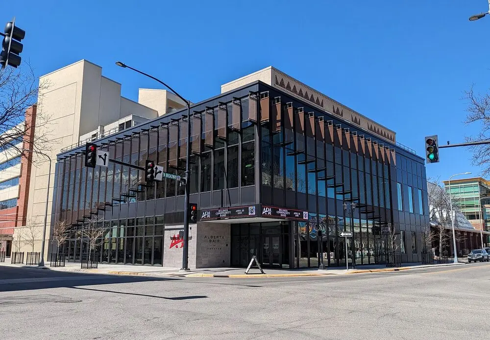 The glass-fronted Alberta Bair Theater on a corner of downtown Billings under a blue sky