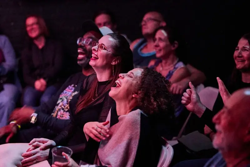 Audience members laughing hard in their seats during a Flyover Comedy Festival show