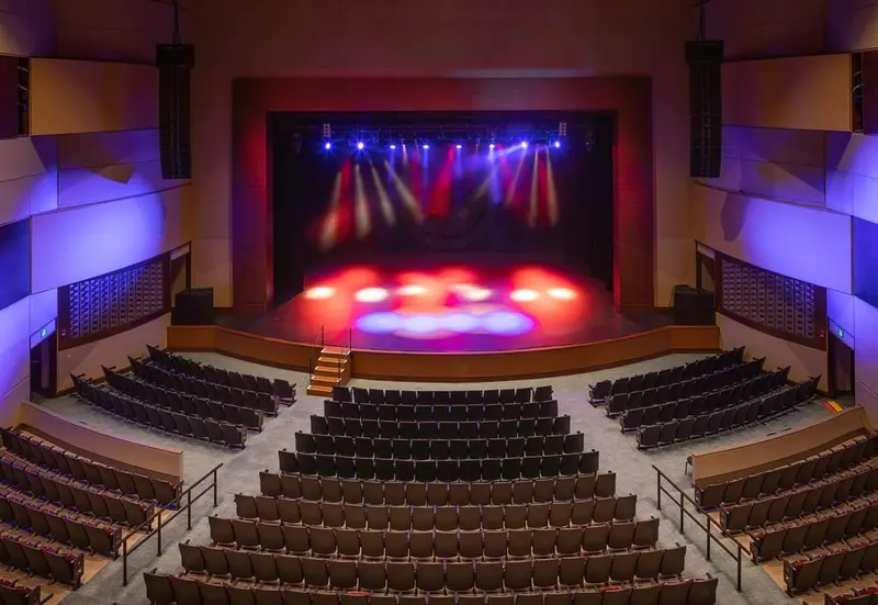 The Montgomery Performing Arts Centre auditorium with its stage washed in red and blue light, seen from the balcony