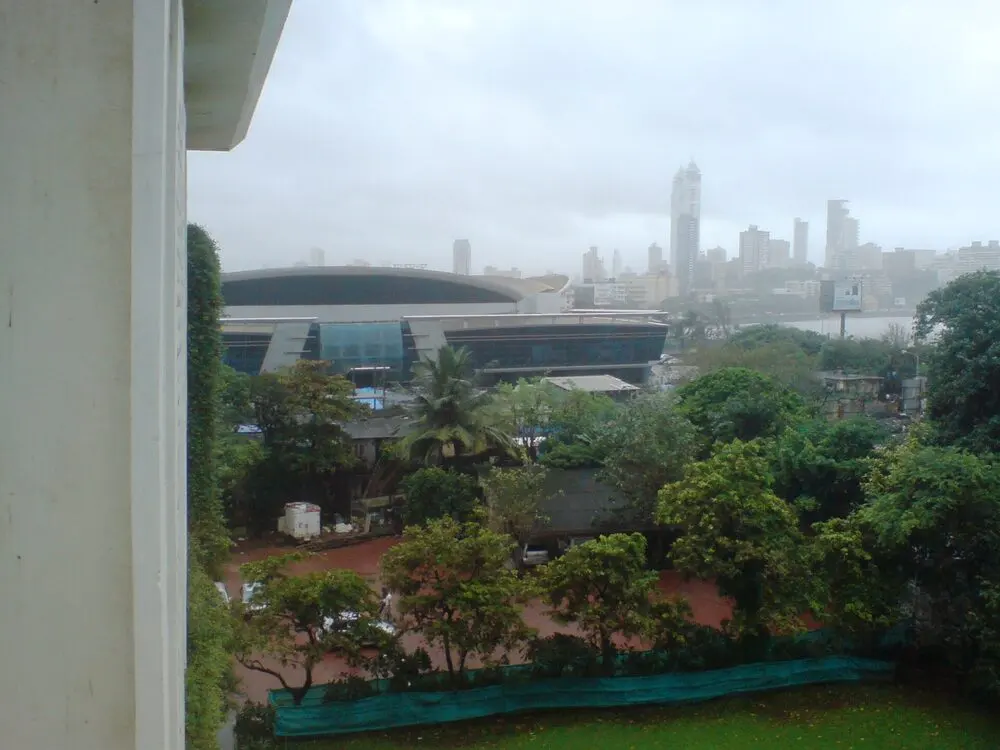The domed NSCI Sardar Vallabhbhai Patel Stadium in Worli, Mumbai, where the festival is held, seen over trees on a hazy day.
