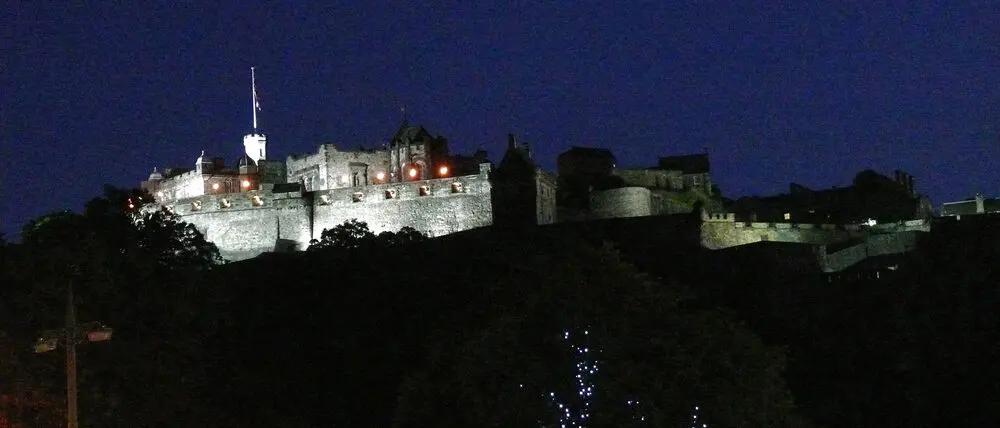 Edinburgh Castle lit at night, seen from Hanover Street at the corner of Princes Street